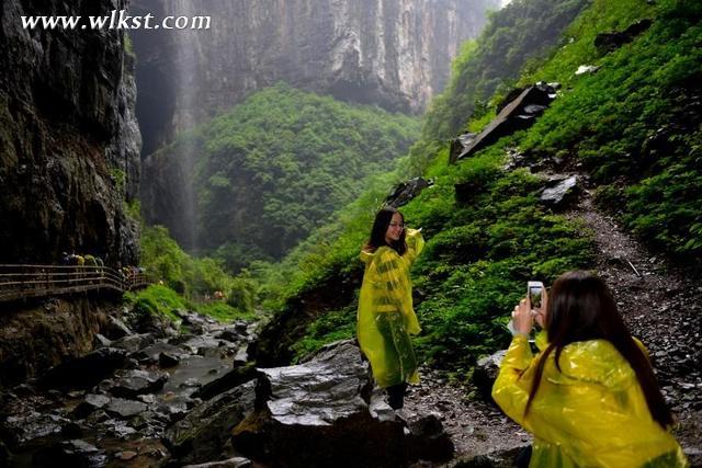 游览途中突然下起小雨，但达人们兴致依旧，图为身穿雨衣的达人在拍照。