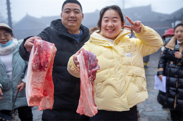 游客赢得土猪肉开心拍照